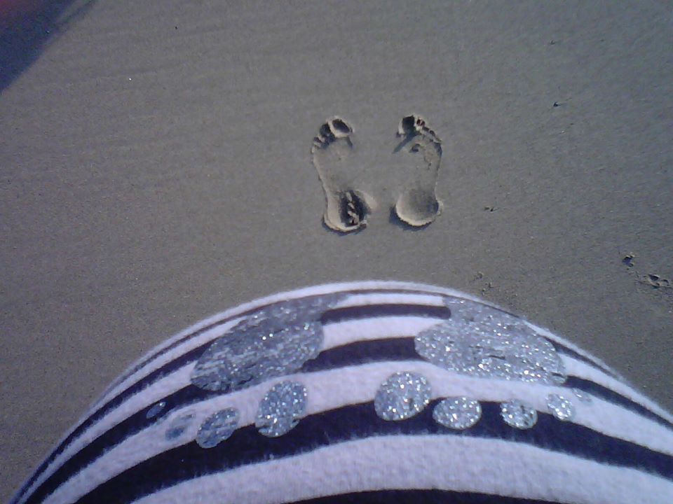 L'empreinte des deux pieds de Maman sur le sable, les deux pieds de Bébé imprimés sur le tee-shirt.