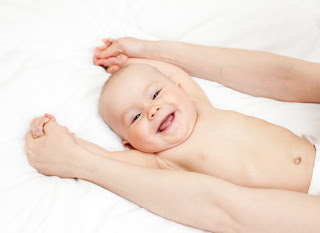 Un bébé rieur lors d'un massage.